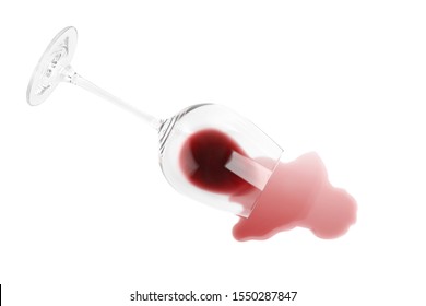 Transparent glass and spilled exquisite red wine on white background, top view