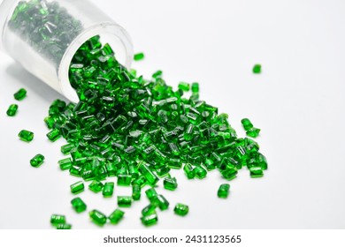 Transparent green masterbatch granules on a white background, this polymer is a colorant for products in the plastics industry