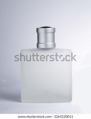 Transparent and opaque bottle of perfume with label on a white background. Feminine and masculine essence. Studio light concept.