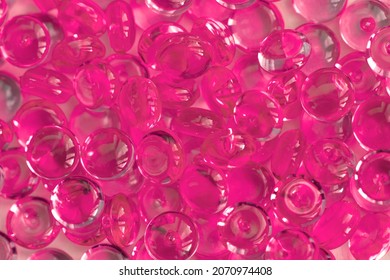 Transparent pink glass marble beads. Acrylic ice stones for decoration. Water drops background. Abstract wallpaper or backdrop for web design