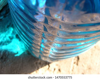 Transparent Plastic Canister With Blue Automobile Liquid (blue Non-freezing Liquid) On The Porch On The Threshold Of The House. On The Bottle Are Located Transverse Swathe Of. Game Of Light Spots. 