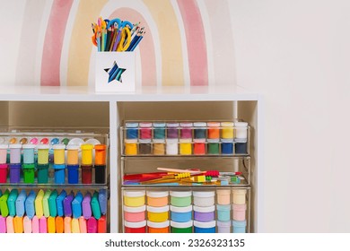 Transparent plastic containers with stationery and supplies for drawing and craft on shelves. White shelving with various material for creativity and art activity. Organizing and storage craft room.  - Shutterstock ID 2326323135