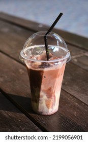 A Transparent Plastic Glass With A Straw With Cold Coffee Or Cocoa On A Wooden Table. Time To Drink Coffee In The City. Coffee To Go. Disposable Cup Close-up. Empty Space For Text, Mockup