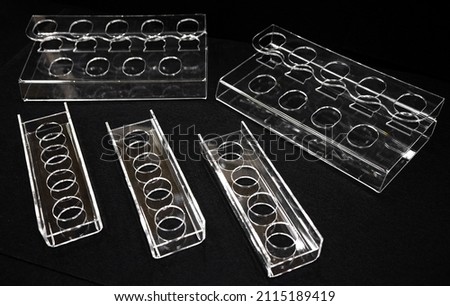 Transparent plastic stands made of organic glass on a black background. Production of advertising materials. Plastic bending on a hot string.