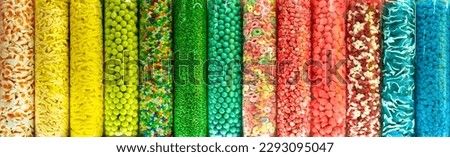Transparent plastic tubes full of colorful candies. Rainbow jelly