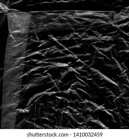 Transparent Plastic Wrap On The Black Background. Plastic Bag Texture. Reusable Trash And Waste.