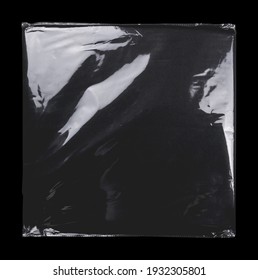 Transparent Plastic Wrap On The Black Background. Clean Blank Texture Overlay Effect Template. Isolated Wrinkle Surface Branding Mock-up. Black Pack Packaging Bag.