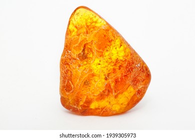 A Transparent Polished Piece Of Yellow Amber On A White Background. Sun Stone. Natural Mineral Material For Jewelry. Amber Texture. Copal. Multicolored Yellow Background. Ancient Fossil Resin