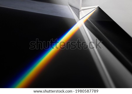 Transparent prism dispersing sunlight splitting into a spectrum on a white background