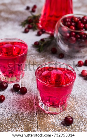 Transparent red drink in a glass on wooden background. Selective focus.