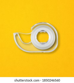 Transparent Scotch Tape Dispenser Isolated On Yellow Background