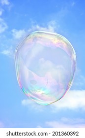 Transparent soap bubble on a background blue sky
