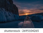 A transparent triangular ice floe under the sun. Sunset. Small Sea. Baikal.