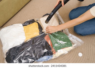 Transparent vacuum bag with warm things for seasonal storage on a blanket. Space saving concept, compressed package for storage organization - Powered by Shutterstock