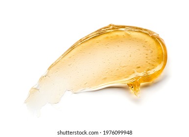 Transparent yellow smear of face cream or golden honey isolated on white background. Golden creamy texture on white background.