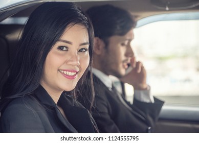 Transport, business trip and people concept. Business woman working secretary with Boss  holding smartphone in car. - Shutterstock ID 1124555795
