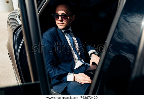 transport, business trip, safety and people\
concept - businessman driving on car back\
seat