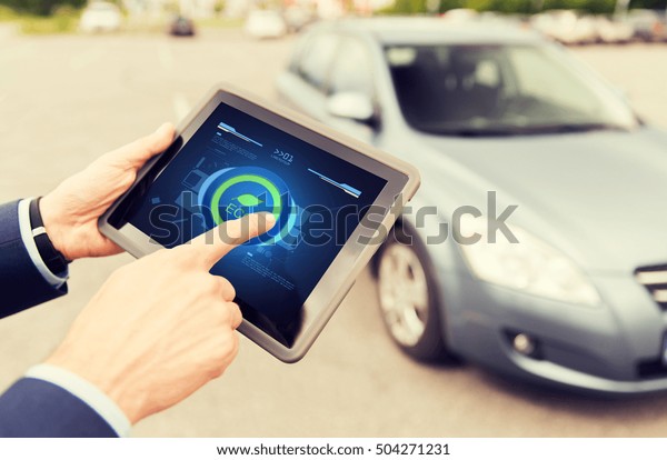 transport, business trip, technology and people
concept - close up of male hands setting eco driving mode on tablet
pc computer and car
outdoors