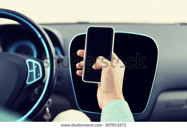 transport, business\
trip, technology and people concept - close up of male hand with\
smartphone driving\
car