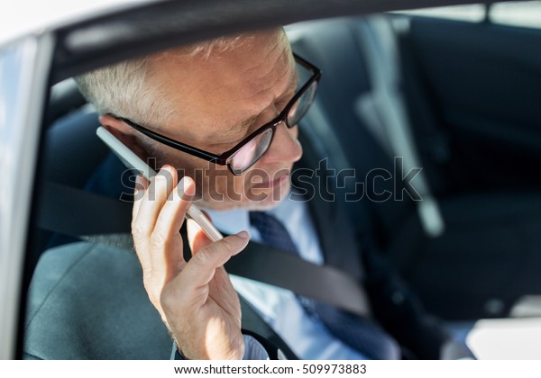 transport, business trip, technology and people
concept - senior businessman calling on smartphone and driving on
car back seat