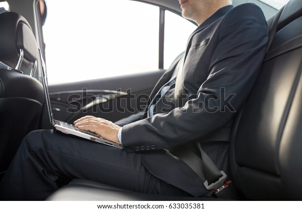 transport,\
business trip, technology and people concept - senior businessman\
with laptop computer driving on car back\
seat