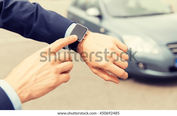 transport,\
business trip, technology, time and people concept - close up of\
male hands with wristwatch on car\
parking
