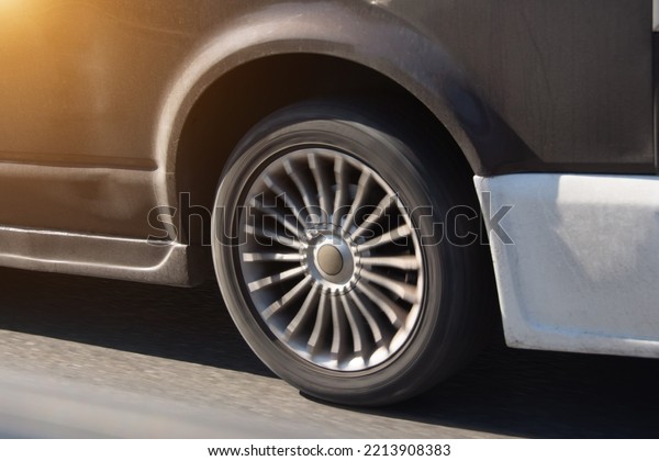Transport,\
driving and motor vehicle, close up detail of wheel, tire and\
breaks dirty blue car parking on asphalt\
road