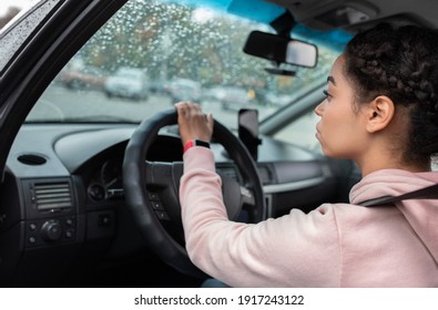 Transport Management, Traffic, Driver Taxi And Traffic. Concentrated Millennial African American Female With Seat Belt, Driving And Looking At Road Through Windshield With Raindrops, Copy Space