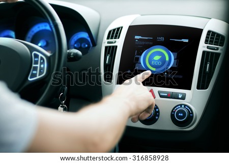transport, modern, green energy, technology and people concept - male hand using car eco system mode