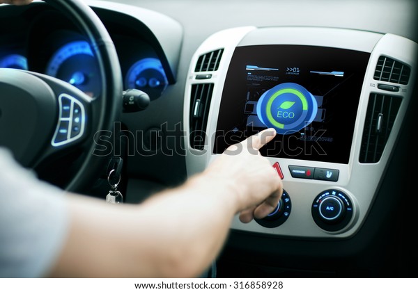 transport, modern, green
energy, technology and people concept - male hand using car eco
system mode