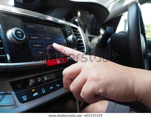Transport, modern and technology\
concept: Male touching on car control panel to use audio\
player