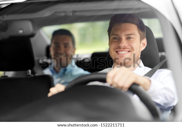 transport, people and taxi concept - happy\
smiling male driver driving car with\
passenger