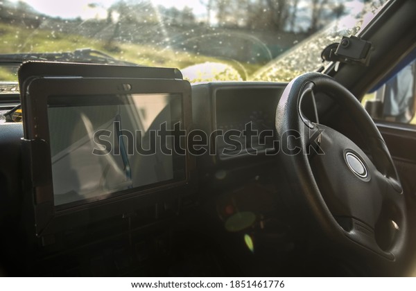 Transport personnel are using data from\
automatic navigation through a modern display.tablet and app using\
wifi, steering wheel in\
background