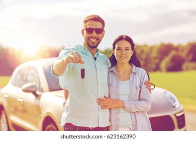 transport, road trip, travel, family and people concept - happy man and woman with car key hugging 