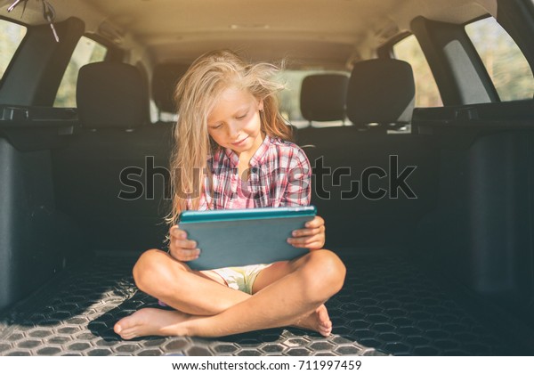 transport, road trip, travel,\
technology and people concept - happy little girl with tablet\
pc