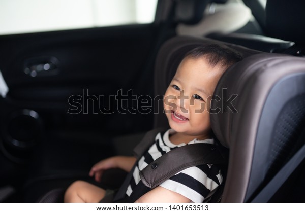 Transport, safety, childhood road trip and people\
concept - Happy baby boy sitting in baby car seat or booster seat,\
Child in auto baby seat in car, Asian boy in summer vacation to\
travel with family.