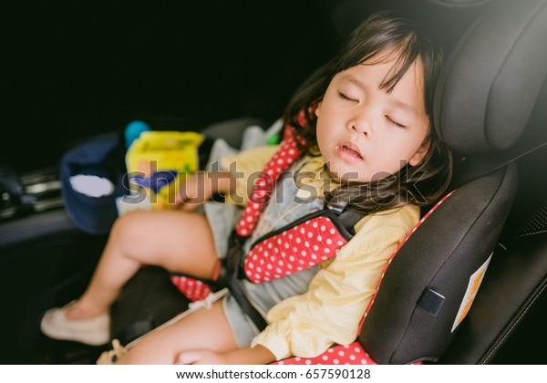 Transport, safety, childhood road\
trip and people concept - happy little girl sleeping in baby car\
seat, Child in auto baby seat in car, Adorable little girl in the\
car.