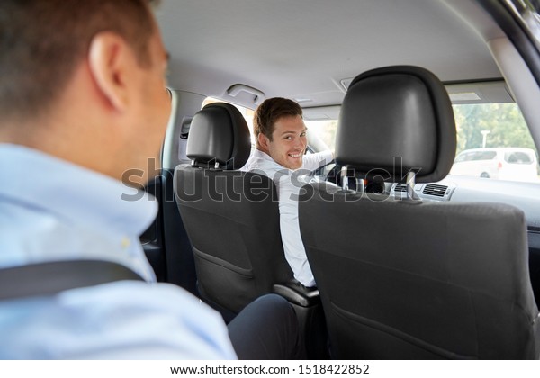 transport, taxi and people concept - male\
driver driving car with\
passenger