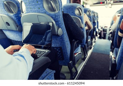 transport, tourism, business trip and people concept - close up of man with laptop typing in travel bus