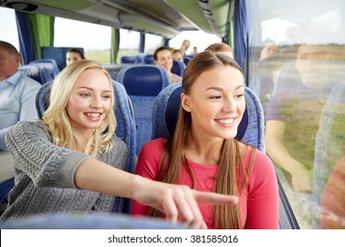 transport, tourism, friendship, road trip and people concept - young women or teenage friends riding in travel bus