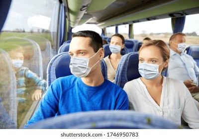 transport, tourism, road trip and people concept - couple wearing face protective medical masks for protection from virus disease with group of passengers or tourists in travel bus