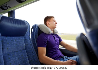 transport, tourism, road trip, rest and people concept - happy young man sleeping in travel bus with inflatable pillow - Powered by Shutterstock