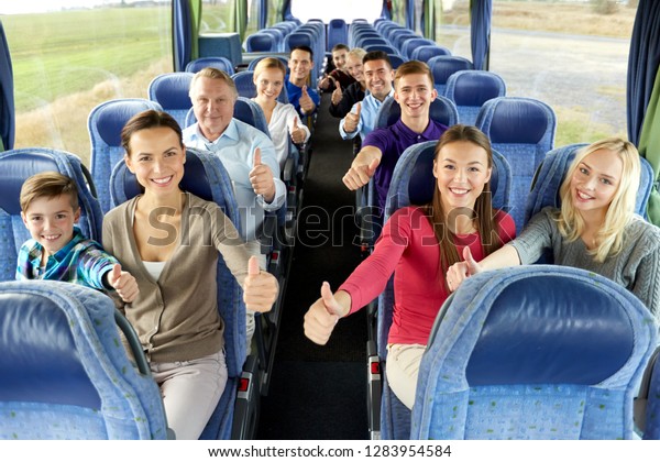 transport, tourism and
travel concept - group of happy passengers travelling by bus and
showing thumbs up