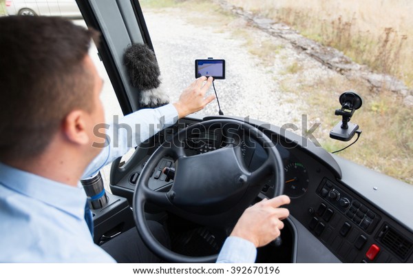 transport, transportation, tourism, navigation and\
people concept - close up of bus driver with gps navigator driving\
passenger bus