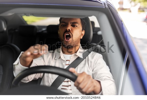 transport, vehicle and people concept - angry indian
man or driver driving
car