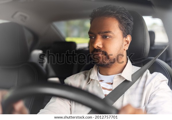 transport, vehicle and people concept - indian man or\
driver driving car
