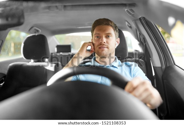 transport, vehicle and
people concept - man or driver with wireless earphones or hands
free device driving
car