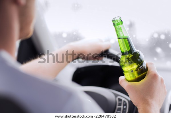 transportation, alcohol,\
vehicle and people concept - close up of man drinking alcohol while\
driving car