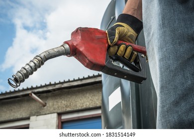 Transportation and Automotive Theme. Caucasian Men in His 40s Hold Diesel Pump Nozzle in His Hand and Preparing For Semi Truck Fueling Procedure.
