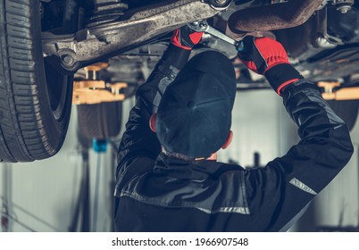 Transportation And Automotive Theme. Modern SUV Car Suspension Maintenance Performed By Caucasian Car Mechanic. 